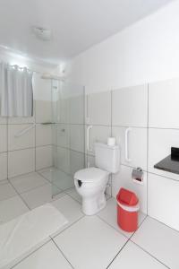 La salle de bains blanche est pourvue d'une douche et de toilettes. dans l'établissement Cantinho da Melão, à Maragogi