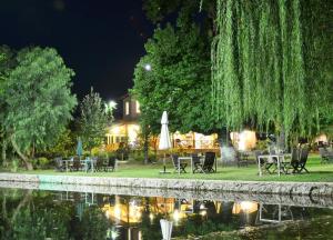 a group of tables and chairs next to a pond at night at Dalya Life in Göcek
