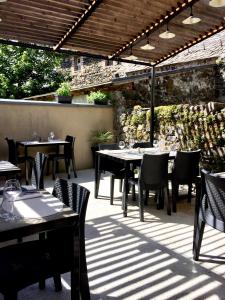 an outdoor dining area with tables and chairs on a patio at Hôtel Restaurant Le Bardière in Laguiole