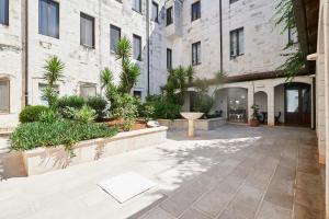 a courtyard in a building with trees and plants at Hotel Sant' Antonio in Alberobello