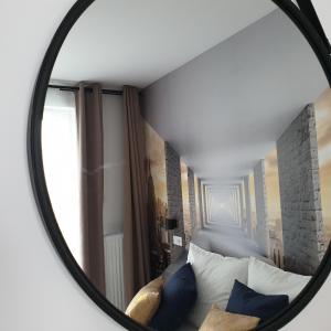 espejo que refleja un dormitorio con cama con almohadas azules en Q Apart SILVER - garaż, klimatyzacja, Netflix, FV, STUDIO, en Łódź