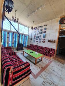 a room with red couches and a green table at Damask Rose, Lebanese Guest House in Jounieh