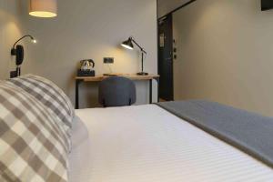 a bedroom with a bed and a desk and a chair at Hotel SUB in Asnières-sur-Seine