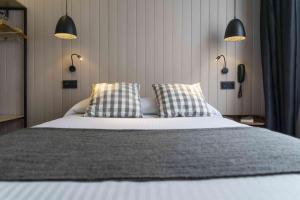 a bedroom with a bed with two pillows on it at Hotel SUB in Asnières-sur-Seine