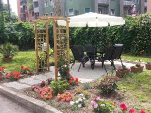 a garden area with a table, chairs, and umbrella at Hotel Garden in Milan