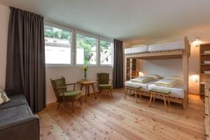 1 Schlafzimmer mit 2 Etagenbetten sowie einem Tisch und Stühlen in der Unterkunft FinKa in Mals im Vinschgau