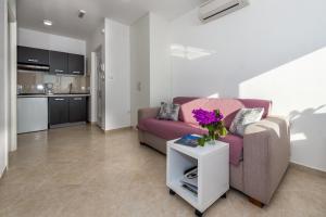 Villa Mirta في تيسنو: غرفة معيشة مع أريكة وطاولة مع زهور