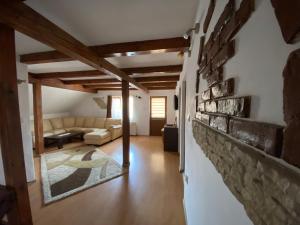 a living room with a couch and a brick wall at Casa Floare de Colt in Cîrţişoara