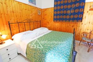アンドラーノにあるGD Case Vacanza - Veranda sul mare -の木製の壁のベッドルーム1室(ベッド1台付)