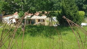 un campo de hierba con una casa en el fondo en Charming Cottage in Chauminet en Sougères-en-Puisaye