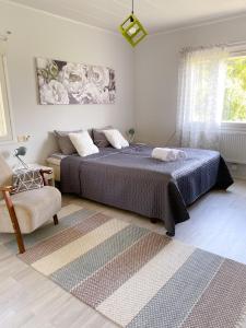 a bedroom with a large bed and a chair at Cozy apartment with sauna in Haapavesi
