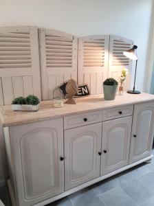 a white cabinet with two potted plants on it at La Maison Coco in Honfleur