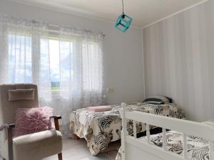 um quarto com 2 camas, uma cadeira e uma janela em Cozy apartment with sauna em Haapavesi