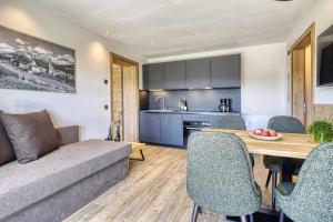 een woonkamer en een keuken met een bank en een tafel bij Chalet Schlossberg Latemar in Nova Ponente