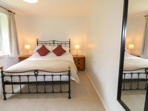 - une chambre avec un lit et un miroir dans l'établissement Tuliptree, à Chesterfield