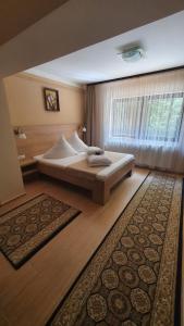 a bedroom with a large bed and a window at Complex Turistic Caprioara in Baia Mare