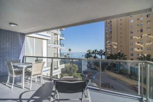 a balcony with chairs and a table and a view of a city at Apartamentos Hipocampos Calpe Rent Apart in Calpe