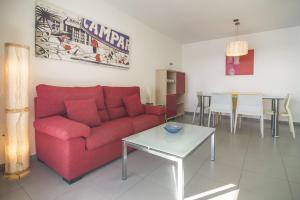 a living room with a red couch and a table at Apartamentos Hipocampos Calpe Rent Apart in Calpe