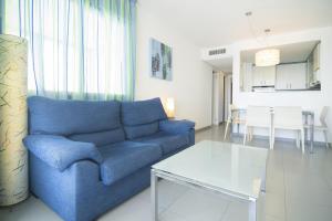 a living room with a blue couch and a table at Apartamentos Hipocampos Calpe Rent Apart in Calpe