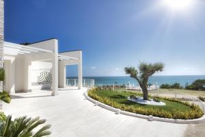 a patio with a tree and the ocean in the background at Baia del Sole Vasto in Vasto