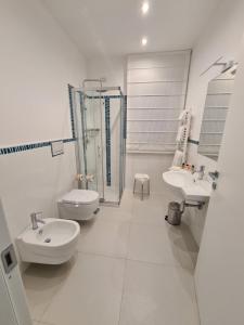 a white bathroom with two sinks and a shower at Baia del Sole Vasto in Vasto