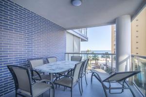 a table and chairs on a balcony with a view of the beach at Apartamentos Hipocampos Calpe Rent Apart in Calpe