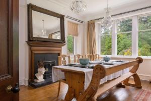 a dining room with a table and a fireplace at Haven Retreat Scotland - Large 4 Bed House with Woodland garden, Aboyne ,Royal Deeside in Aboyne