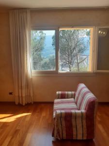 een woonkamer met een bank en een groot raam bij Parco dei Gelsomini in Ascoli Piceno