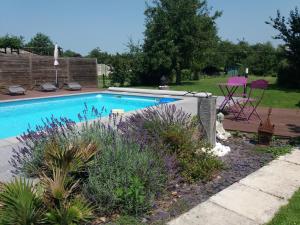 uma piscina em um quintal com mesa e cadeiras em chambres d hotes ,hotel ,Secret d'une Nuit a vicq prės de onnaing,avec piscine em Valenciennes
