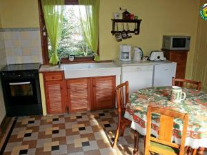 una cucina con tavolo, lavandino e piano cottura di Maison de campagne avec cheminée, jardin clos et équipements modernes – à Herly - FR-1-376-10 a Herly