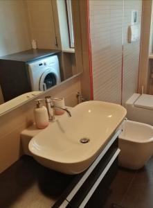 une salle de bain avec un lavabo et une machine à laver dans l'établissement VASARI APARTMENT, à Vérone 21 autres photos