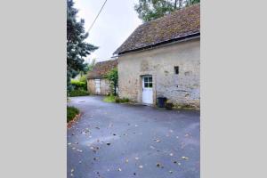 an old stone building with a driveway in front of it at Studio "Rêves de gamins" proche du pôle Européen et circuit des 24h, Champagné in Champagné