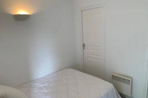 a white bedroom with a bed and a door at Studio "Rêves de gamins" proche du pôle Européen et circuit des 24h, Champagné in Champagné