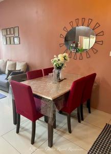 a dining room table with red chairs and a mirror at KR Swiss Garden Resort Residences Kuantan in Kuantan