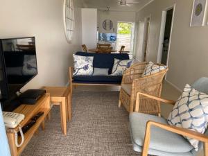 a living room with a couch and a tv at Vaima Beachfront Apartments in Rarotonga