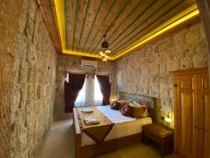 a bedroom with a bed in a stone wall at Walnut House in Goreme