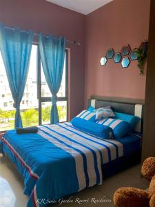 1 dormitorio con cama azul y ventana en KR Swiss Garden Resort Residences Kuantan, en Kuantan