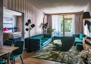 a living room with green furniture and a bedroom at Waldhaus Jakob in Konstanz