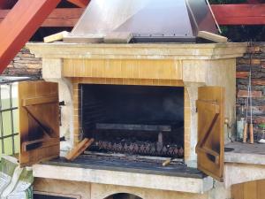 a stone fireplace with a grill on top of it at Apartmány Eva in Janske Lazne
