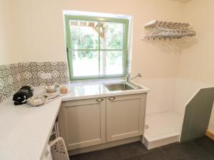 a kitchen with a sink and a window at Old Wood Coach House in Lincoln +24 photos