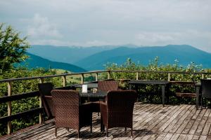 a table and chairs on a deck with a view of mountains at Kamyanka in Mizhhirya