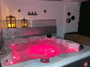 a pink bath tub with lights in a bathroom at Villa avec maxi Jacuzzi aux Portes de Paris in Arcueil
