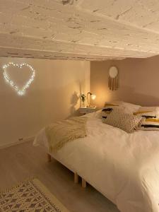 Schlafzimmer mit einem Bett mit Herzlicht an der Wand in der Unterkunft Villa avec maxi Jacuzzi aux Portes de Paris in Arcueil