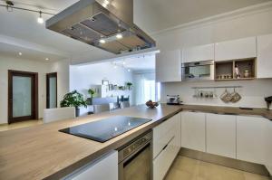 a kitchen with white cabinets and a counter top at Luxury Apartment with Pool and Terrace, Top Location in Sliema