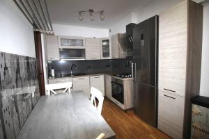 cocina con mesa y nevera grande en Orchidea Apartment, en Lublin