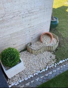 a garden with a bush in a bed of rocks at Buarcos Luxury Guest house in Figueira da Foz
