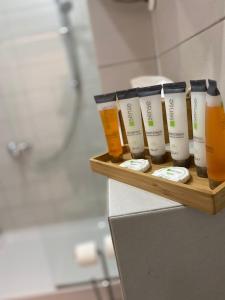 een rij van vier flessen zonnebrandcrème op een plank in een badkamer bij De Silva Studio Adia 4 in Mamaia