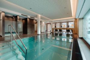 a swimming pool with a glass floor in a building at PoSt Boutique Apartments in Maria Alm am Steinernen Meer