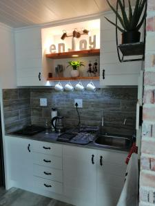 a kitchen with white cabinets and a sink at Just Chill Betty's Bay in Bettyʼs Bay