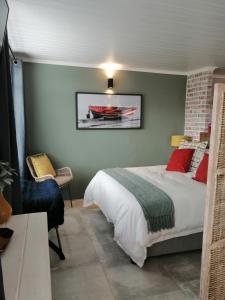 a bedroom with a bed and a chair in it at Just Chill Betty's Bay in Bettyʼs Bay